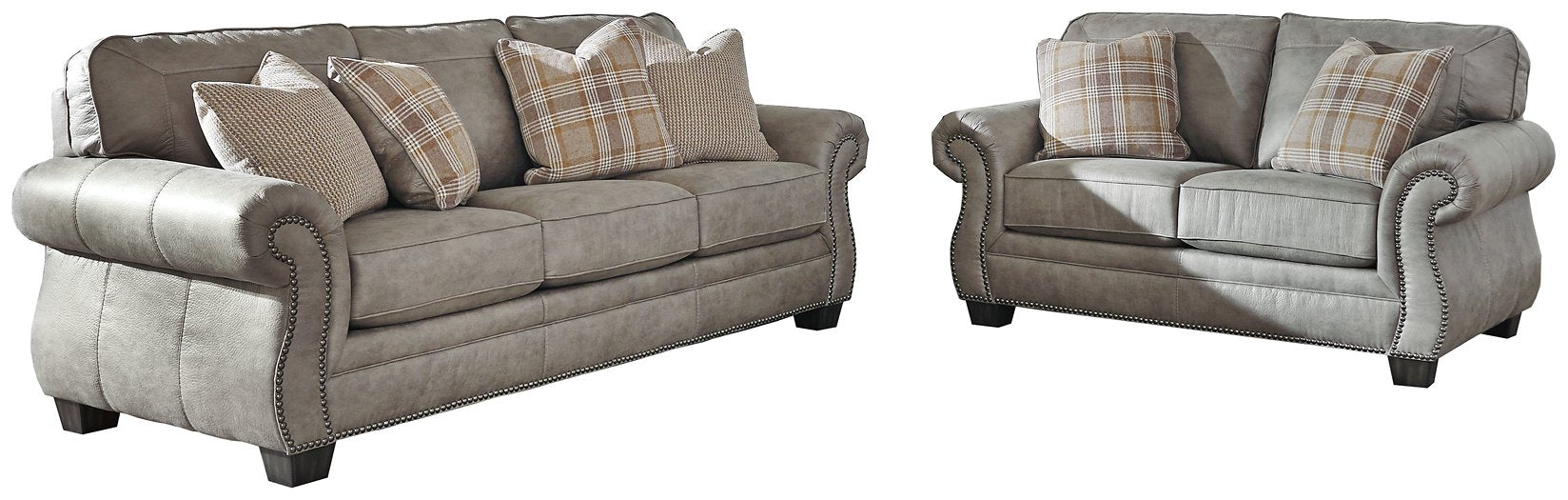 Olsberg sofa and loveseat set with steel gray upholstery, nailhead trim, and plaid accent pillows. Classic and cozy design.